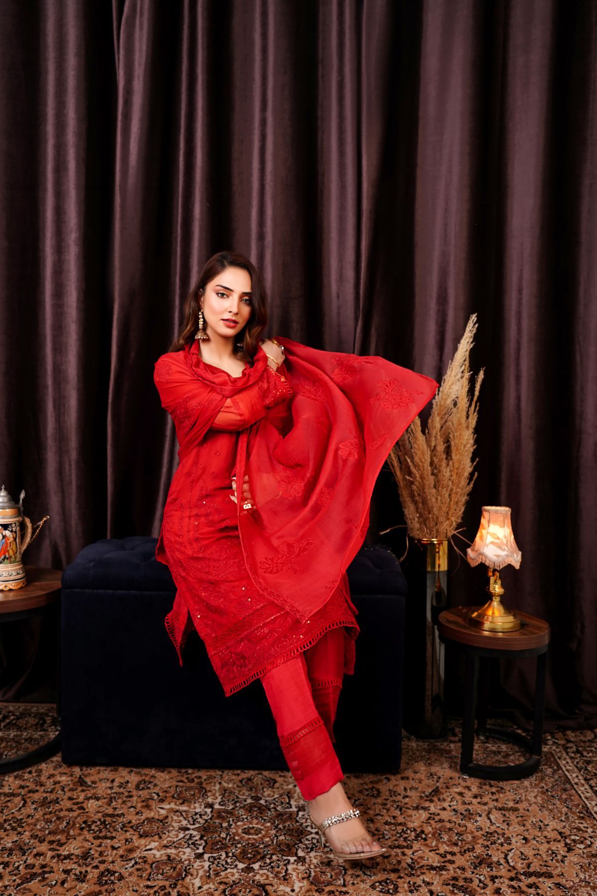 Red three piece Pakistani ladies suit styled for a formal event